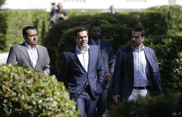 Greece&#039;s Prime Minister Alexis Tsipras, center, leaves after a meeting with leaders of Greek political parties at the Presidential Palace in Athens, Monday, July 6, 2015. Greece and its membershi ...