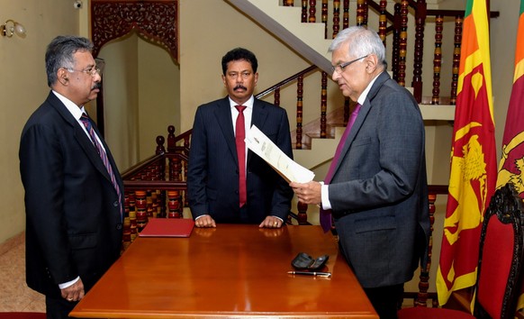 epa10072339 A handout photo made available by the Sri Lankan President&#039;s Media Division shows Sri Lankan Prime Minister Ranil Wickremesinghe (R) taking the oath as interim president of Sri Lanka  ...