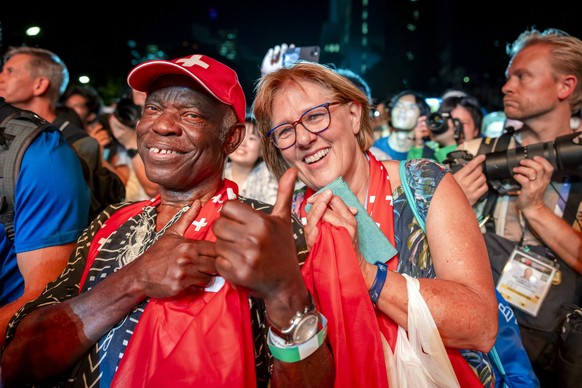 Father Safuka and Ruth Kambundji attend the medal ceremony with her daughter Gold medalist Ditaji Kambundji of Switzerland, center, during the medal ceremony for the women's 100 meters final on d ...