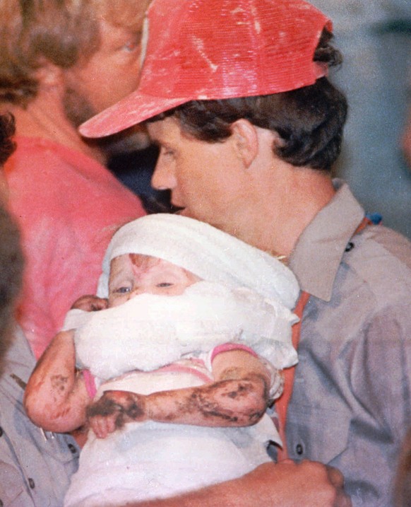 FILE - In this October 1987 file photo, a rescue worker carries 18-month-old Jessica McClure to safety in Midland, Texas, after being trapped for 58 hours after she plunged 22 feet into an abandoned w ...