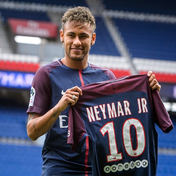 epa06124293 Brazilian striker Neymar Jr. poses for photographs with his new PSG jersey after a press conference at the Parc des Princes stadium in Paris, France, 04 August 2017. Neymar Jr is presented ...