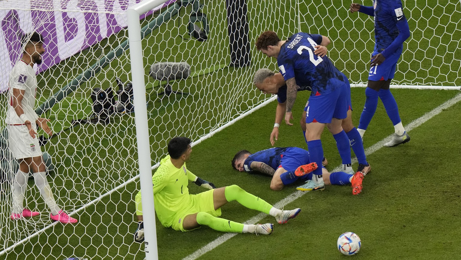 Christian Pulisic of the United States lays injured on the pitch after he scoring his side&#039;s opening goal during the World Cup group B soccer match between Iran and the United States at the Al Th ...