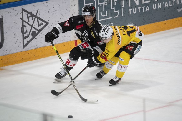 Lugano&#039;s player Samuel Guerra and Bern&#039;s player Noah Fuss, from left, fight for the puck, during the preliminary round game of National League Swiss Championship between HC Lugano and SC Ber ...