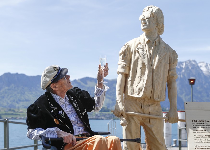 Der Schweizer Musiker Polo Hofer posiert neben seinem Denkmal, am Dienstag, 16. Mai 2017, im Hafen in Oberhofen am Thunersee. Die Statue wurde vom Kuenstler Inigo Gheyselinck aus einer Weisstanne aus  ...
