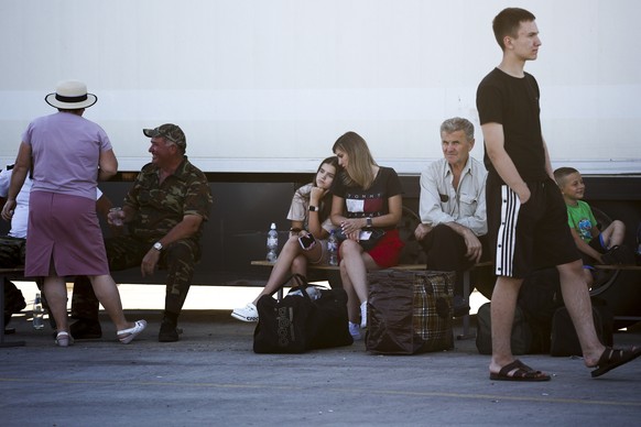 People wait for a ferry to Crimea near the village of Ilyich, Krasnodar region of Russia, on Monday, July 17, 2023. An attack before dawn Monday damaged part of a bridge linking Russia to Moscow-annex ...