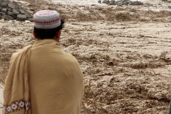 epa11925593 A person looks at the overflowing Tarnak River after torrential rains in Kandahar, Afghanistan, 26 February 2025. At least 29 people were killed in rain-related incidents in Afghanistan in ...
