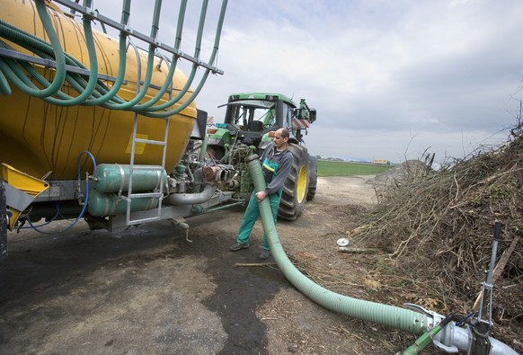 THEMENBILD EIDGENOESSISCHE ABSTIMMUNG ENERGIEGESETZ -- Landwirt Peter Wyss fuellt am 3. April 2007 in Ittigen, Kanton Bern, den Tank des Traktors mit Guelle aus vergorenen Rohstoffen aus der hofeigene ...