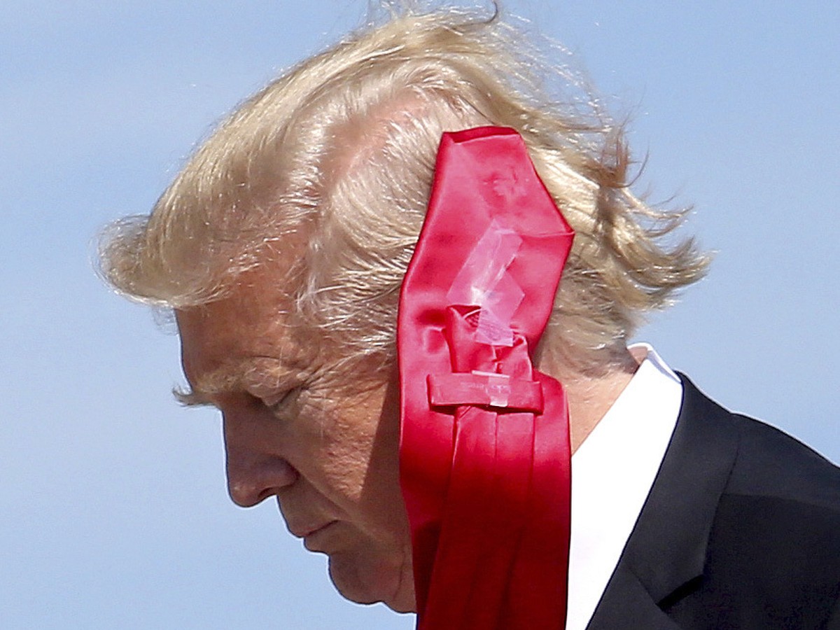 Wind blows President Donald Trump's tie as he arrives at Orlando International Airport for a visit to St. Andrew Catholic School in Orlando, Fla., Friday, March 3, 2017. (Joe Burbank/Orlando Sent ...