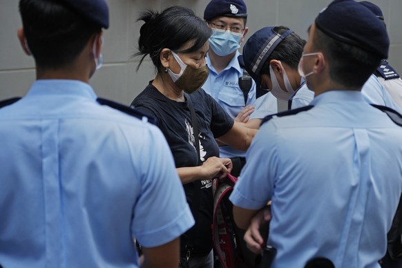 Chen Baoying, center, one of the four protesters is frisked by police officers during a protest against an election committee that will vote for the city&#039;s leader in Hong Kong Sunday, Sept. 19, 2 ...