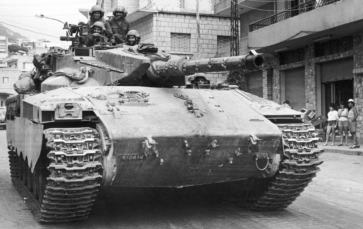 Children watch an Israeli-built Merkava tank of the Israeli Defence Forces enter Christian and Israeli-held East Beirut, on July 13, 1982. A ceasefire has been maintained around the Lebanese captal af ...