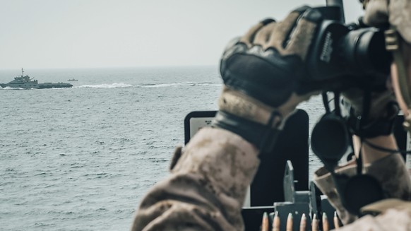 Ein US-Soldat beobachtet ein iranisches Schiff in der Strasse von Hormus. (Foto: US MARINE CORPS/STAFF SGT. DONALD HOLBERT via EPA Keystone)
