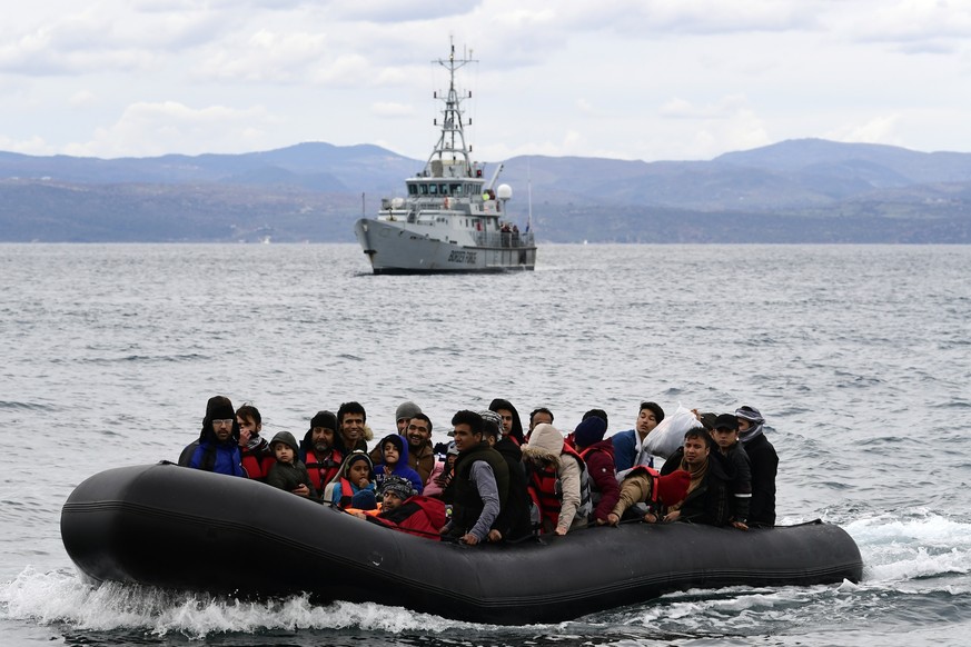 FILE - In this Friday, Feb. 28, 2020 file photo, migrants arrive aboard a dinghy accompanied by a Frontex vessel at the village of Skala Sikaminias, on the Greek island of Lesbos, after crossing the A ...