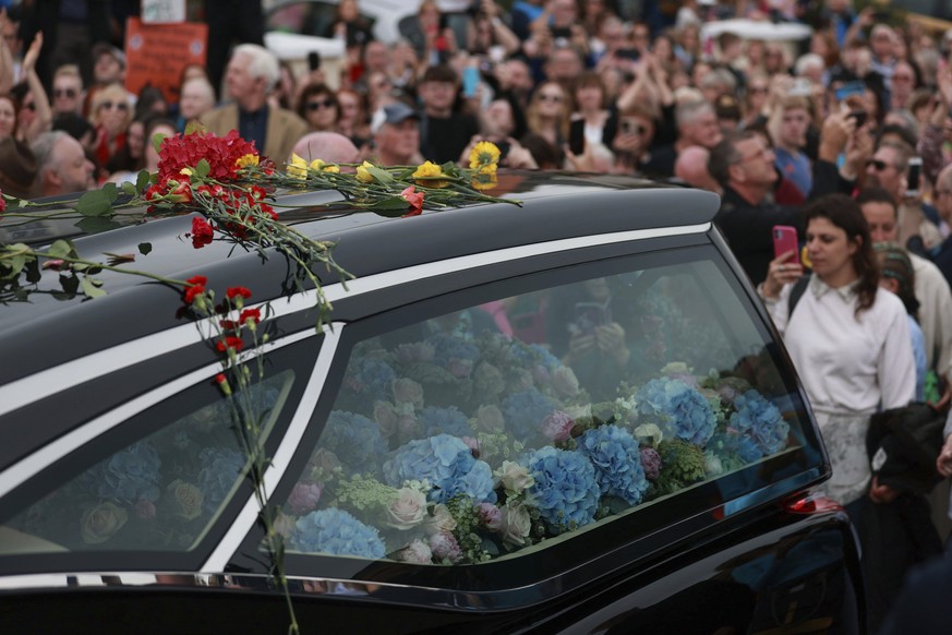 Fans of Sinead O&#039;Connor line the street as her funeral cortege passes through her former hometown of Bray, Co Wicklow, Ireland, Tuesday, Aug. 8, 2023. O?Connor?s family invited the public to line ...