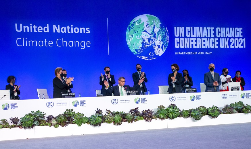 epa09580854 Alok Sharma (C), President COP26 receives a standing ovation during the Plenary session of the COP26 UN Climate Change Conference in Glasgow, Britain, 13 November 2021. The 2021 United Nat ...