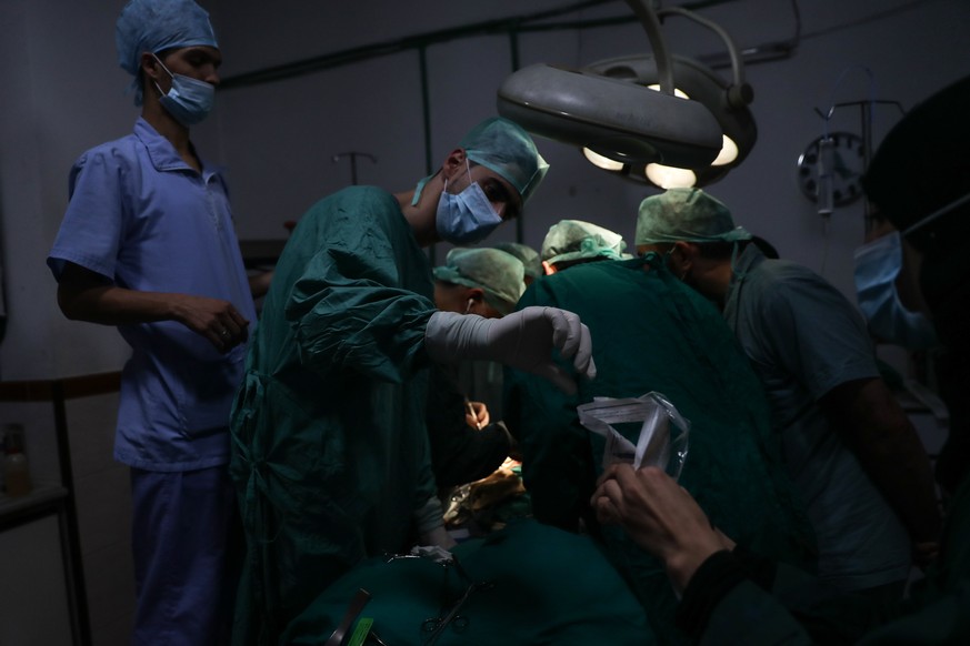 epa06260124 Dr. Husam performs surgery with a consultation from another doctor via a messaging app, with his team at a unit of the Damascus Countryside Specialized Hospital in Douma, Syria, 11 October ...