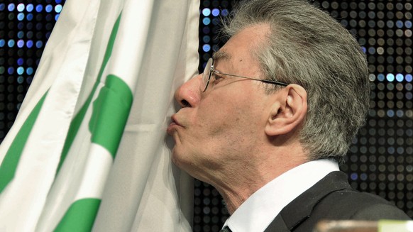 Former Northern League party leader and founder Umberto Bossi, kisses his party flag during a party rally in Bergamo, northern Italy, Tuesday, April 10, 2012. Bossi, whose support kept Silvio Berlusco ...