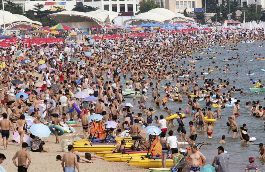 In this photo released by the Chinese news agency Xinhua tourists and citizens frolic on the bathing beach in Qingdao, east China's Shandong province, on Thursday July 17, 2008. The costal city i ...