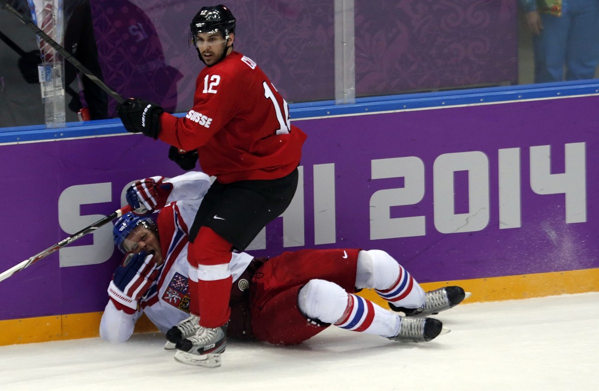 epa04079940 Zbynek Michalek (L) of Czech Republic fights for the puck with Switzerland player Luca Cunti (R) during the Men's Preliminary Round Group C match between Switzerland and the Czech Rep ...