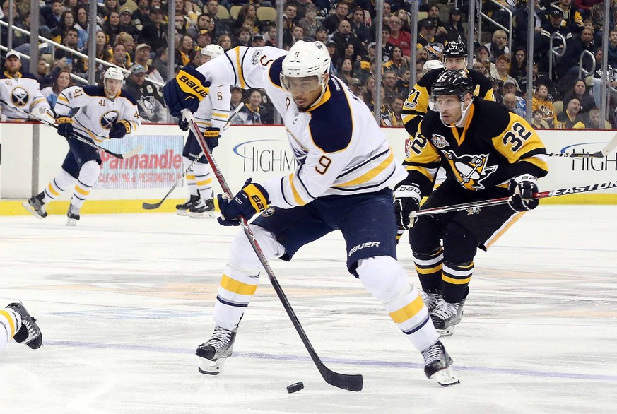 Mar 5, 2017; Pittsburgh, PA, USA; Buffalo Sabres left wing Evander Kane (9) moves the puck ahead of Pittsburgh Penguins defenseman Mark Streit (32) during the third period at the PPG PAINTS Arena. The ...