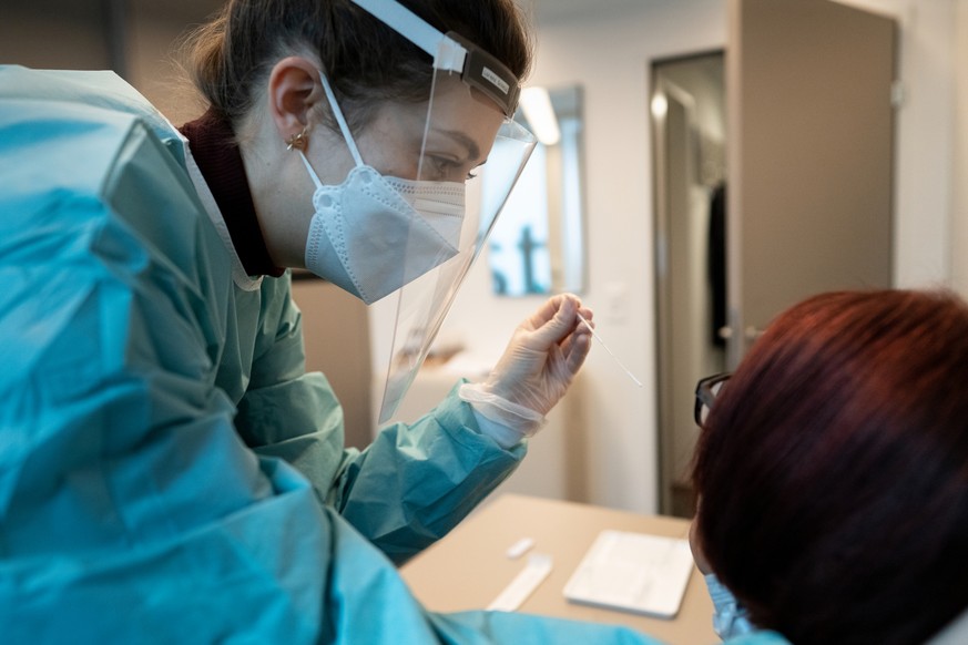 Eine Apothekerin in vorschriftsmaessiger Schutzkleidung macht bei einer Frau einen Abstrich fuer einen Covid-19 Antigen-Schnelltest in Apotheke TopPharm Apotheke am Paradeplatz am Dienstag, 3. Novembe ...