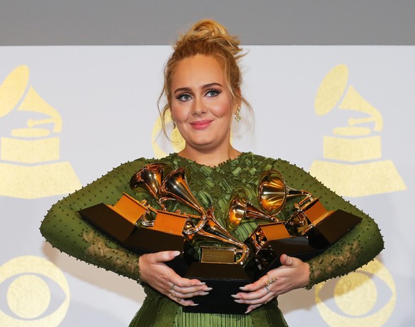 Adele holds the five Grammys she won including Record of the Year for &quot;Hello&quot; and Album of the Year for &quot;25&quot; during the 59th Annual Grammy Awards in Los Angeles, California, U.S. , ...