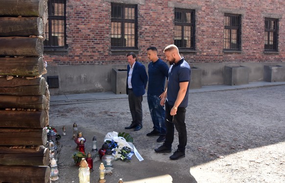 HANDOUT --- 07.06.2018, Polen, Ausschwitz: Christoph Heubner, Vizepraesident des Internationalen Auschwitz Komitees, und die Rapper Farid Bang und Kollegah stehen bei der Niederlegung eines Blumengebi ...