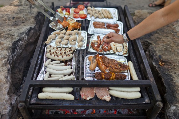 ZUR JAHRESMEDIENKONFERENZ DES FLEISCH-FACHVERBANDES STELLEN WIR IHNEN AM MITTWOCH 13. APRIL 2016 FOLGENDES ARCHIVBILD ZUR VERFUEGUNG. - Die Wurstwaren und das Fleisch liegen auf dem Grillrost, brutzel ...