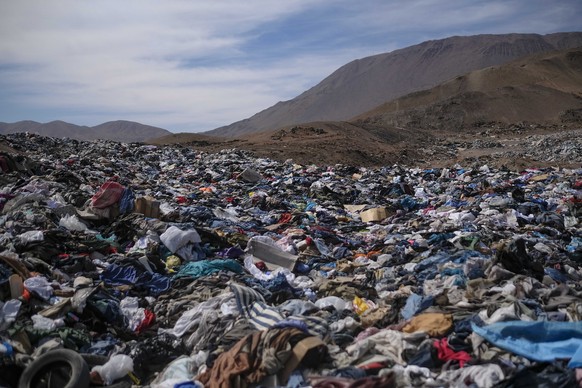 A large pile of second-hand clothing covers the sand near La Mula neighborhood in Alto Hospicio, Chile, Monday, Dec. 13, 2021. Chile is a big importer of second hand clothing, and unsold items are dum ...