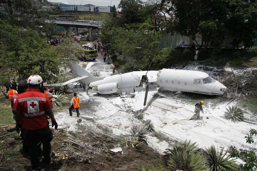 A white Gulfstream jet that appears broken in half near the center, lies engulfed in foam sprayed by firefighters, in Tegucigalpa, Honduras, Tuesday, May 22, 2018. The private jet crashed off the end  ...