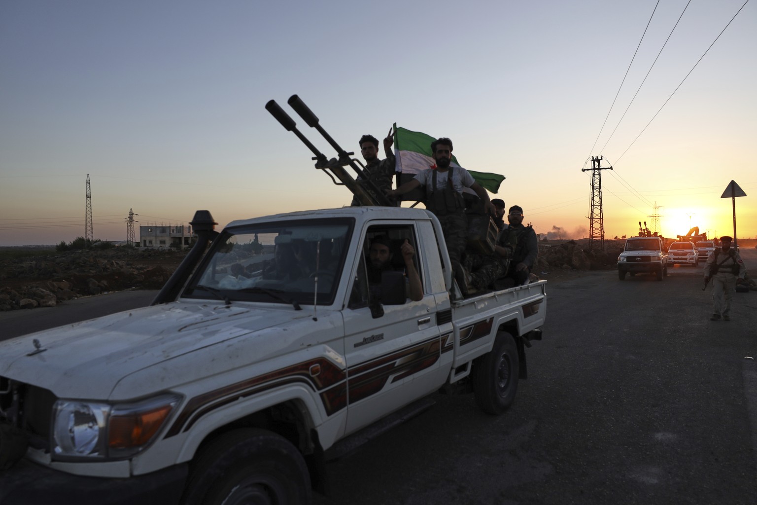 A convoy of government forces drives toward Sweida city where clashes erupted between government troops and Druze militias as it passes through Mazraa village in southern Syria, Tuesday, July 15, 2025 ...