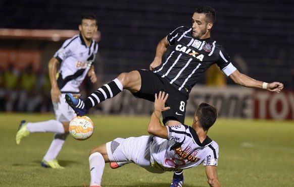 Renato Augusto of Brazil&#039;s Corinthians, center, takes control of the ball as Nicolas Milessi of Uruguay&#039;s Danubio falls back onto the pitch, during a Copa Libertadores soccer game in Montevi ...