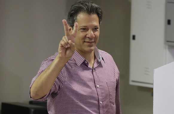 Workers&#039; Party presidential candidate Fernando Haddad, flashes a vee sign after casting his vote, in Sao Paulo, Brazil, Sunday, Oct. 7, 2018. The former Sao Paulo mayor surged into second place a ...