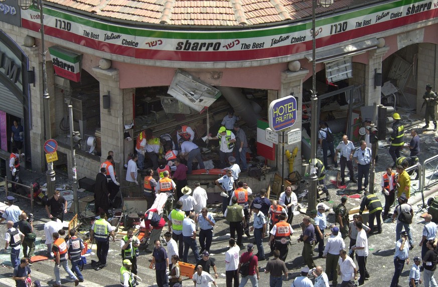 Police and medics surround the scene of a bomb explosion in a restaurant downtown Jerusalem Thursday, Aug. 9, 2001. A bomb exploded in the pizza restaurant Sbarro at lunchtime on Thursday, killing at  ...