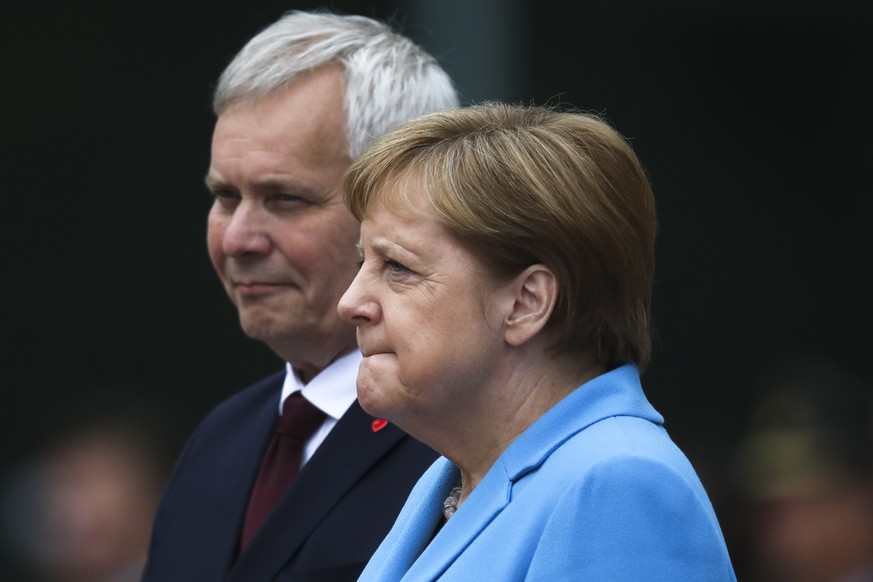 German Chancellor Angela Merkel and Prime Minister of Finland Antti Rinne listen to the national anthems during the welcoming ceremony at the chancellery in Berlin, Germany, Wednesday, July 10, 2019.  ...