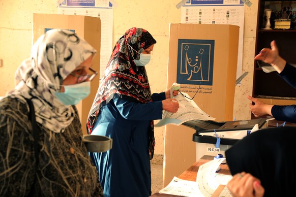 epa09516760 Iraqis vote during the parliamentary election at a polling station in Baghdad's Sadr district, Iraq on 10 October 2021. Iraqis are to elect the new 329 members of the Council of Representa ...