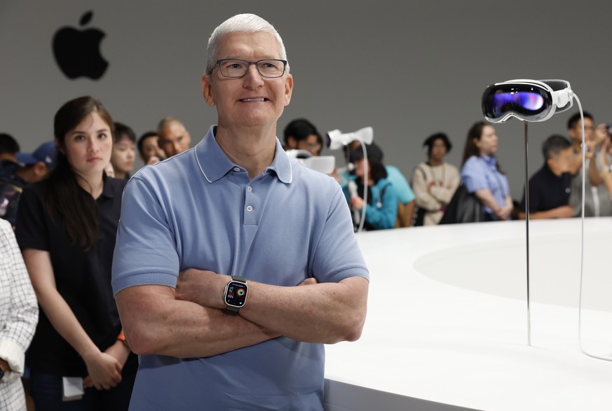 epa10675114 Apple CEO Tim Cook (R) reacts as developers and members of the media photograph and examine products following the keynote address for the 2023 Apple Worldwide Developers Conference (WWDC) ...