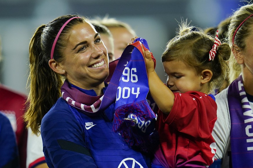 FILE -United States&#039; Alex Morgan holds her daughter, Charlie, as she listens to Cindy Parlow Cone, president of the U.S. Soccer Federation, speak during an event with the federation, U.S. Women&# ...
