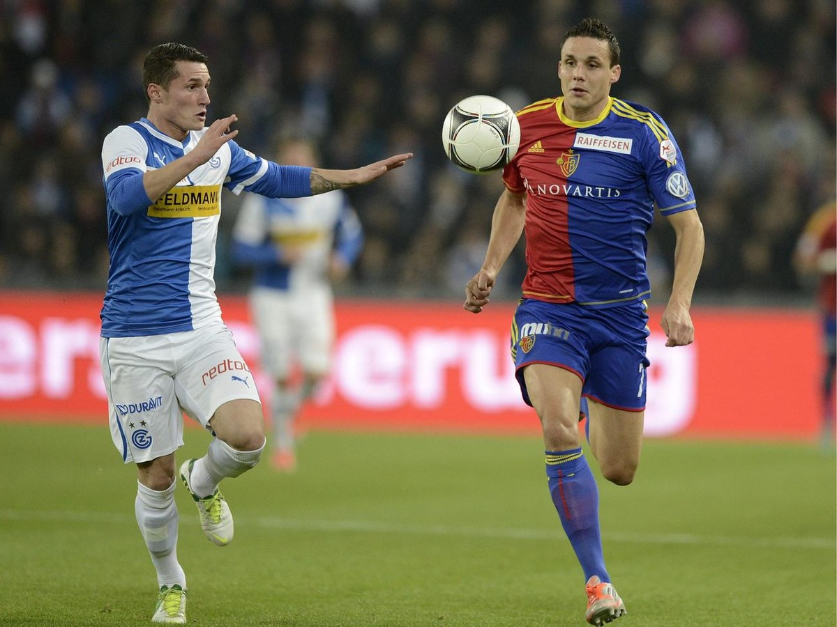 Grasshopper's Taulant Xhaka, left, fights for the ball against Basel's David Degen, right, during the Super League soccer match between FC Basel 1893 and Grasshopper Club Zuerich at the St.  ...