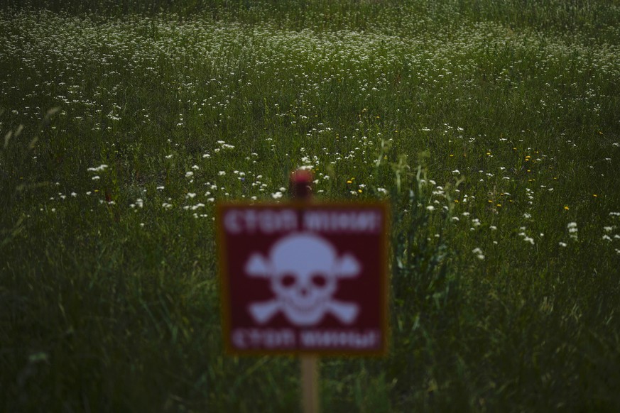 A danger sign warning about land mines is posted in a field blanketed with wildflowers near Lypivka, on the outskirts of Kyiv, Ukraine, Tuesday, June 14, 2022. Russia&#039;s invasion of Ukraine is spr ...