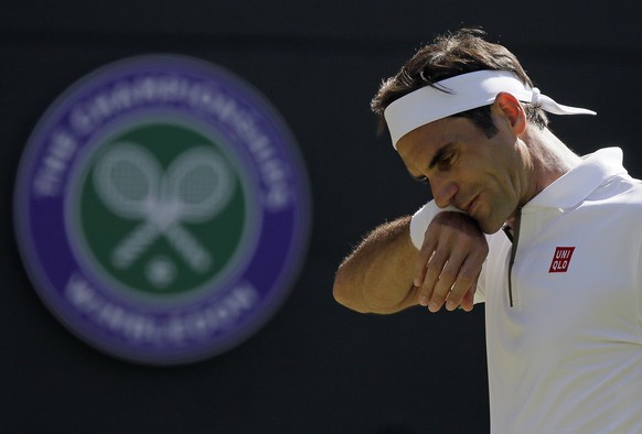 Switzerland&#039;s Roger Federer wipes his face as he plays Britain&#039;s Jay Clarke in a Men&#039;s singles match during day four of the Wimbledon Tennis Championships in London, Thursday, July 4, 2 ...