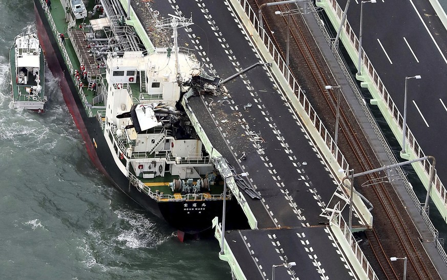 A tanker is seen after it slammed into the side of a bridge connecting the airport to the mainland, damaging part of the bridge and the vessel in Osaka, western Japan, Tuesday, Sept. 4, 2018. A powerf ...