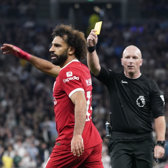 Referee Simon Hooper shows the yellow card to Liverpool&#039;s Mohamed Salah during the English Premier League soccer match between Tottenham Hotspur and Liverpool at the Tottenham Hotspur Stadium, in ...
