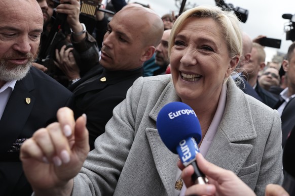 French far-right leader Marine Le Pen smiles as she arrives for a campaign stop Monday, April 18, 2022 in Saint-Pierre-en-Auge, Normandy. French President Emmanuel Macron is facing off against far-rig ...