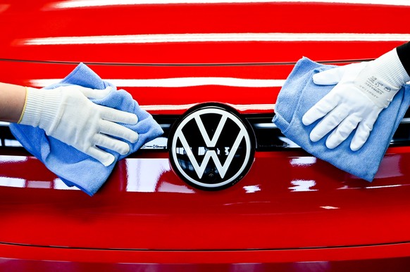 epa09910718 Volkswagen employees clean a Volkswagen logo on a electric cars assembly line at the Volkswagen (VW) vehicle factory in Zwickau, Germany 26 April 2022. In 2021 Volkswagen doubled its elect ...