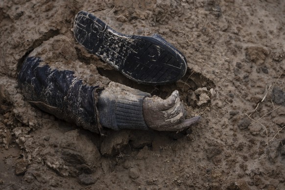 The hand of a corpse emerges from a mass grave in Bucha, on the outskirts of Kyiv, Ukraine, Monday, April 4, 2022. Russia is facing a fresh wave of condemnation after evidence emerged of what appeared ...