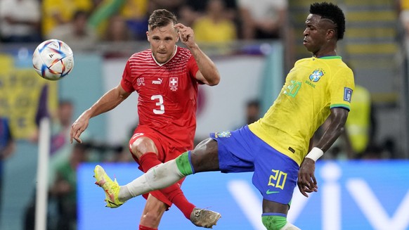 Switzerland's Silvan Widmer, left, and Brazil's Vinicius Junior challenge for the ball during the World Cup group G soccer match between Brazil and Switzerland, at the Stadium 974 in Doha, Qatar, Mond ...