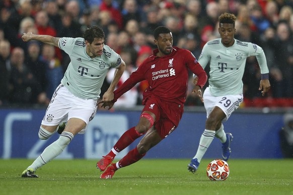 Liverpool&#039;s Georginio Wijnaldum, center, competes for the ball with Bayern midfielder Javi Martinez, left, and Bayern forward Kingsley Coman during the Champions League round of 16 first leg socc ...