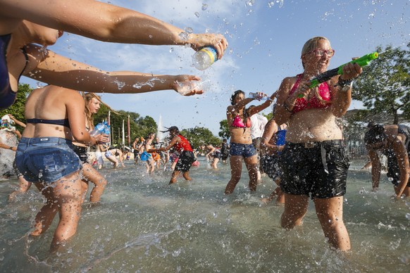 People throw water at each other during a 10-minute long water battle flash mob in Lausanne, Switzerland, Friday, July 3, 2015. The temperatures have been reaching over 35 degrees Celsius for several  ...