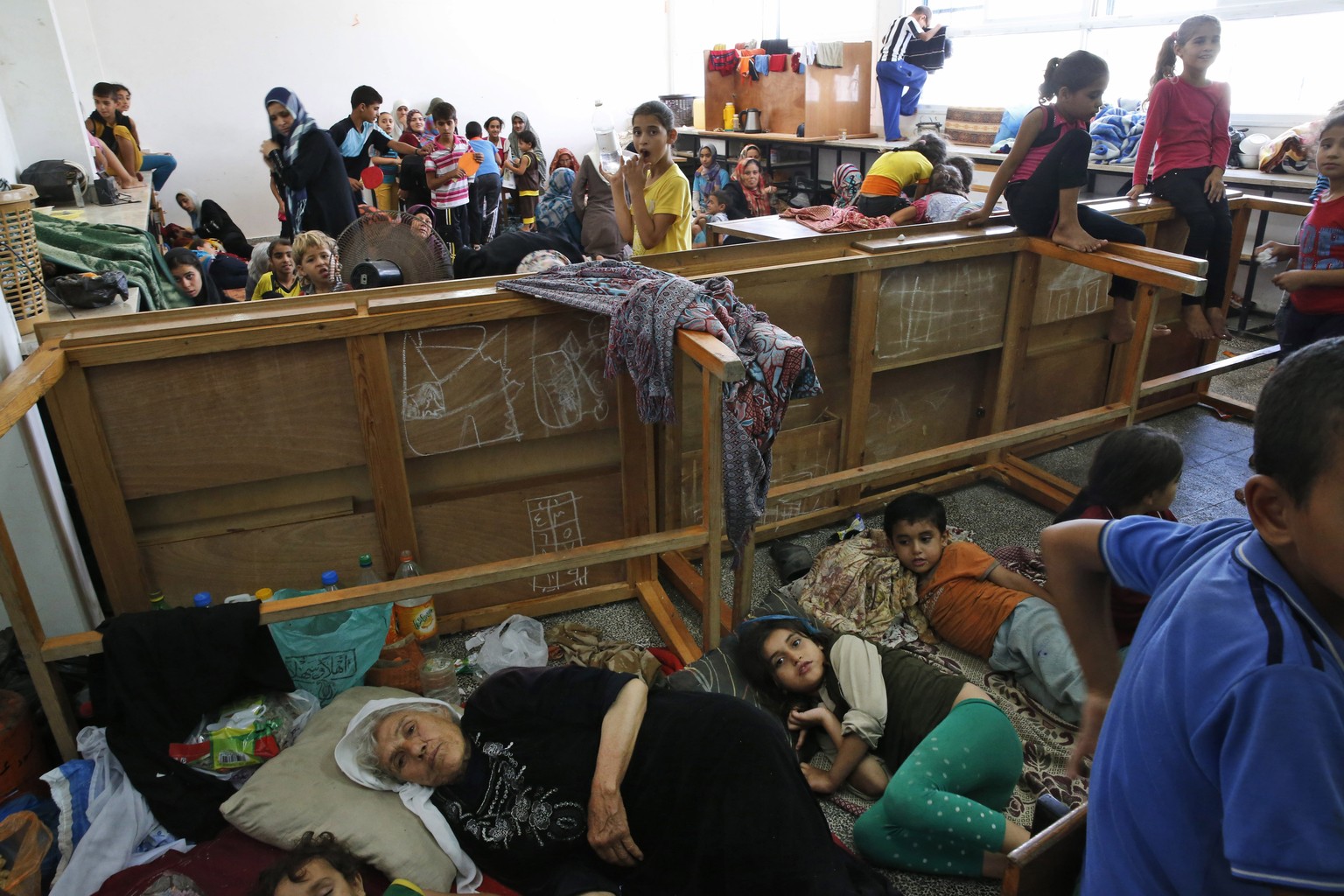 FILE - In this Saturday, July 19, 2014, file photo, Palestinians live at a United Nations school where dozens of families have sought refuge after fleeing their homes following heavy Israeli forces&#0 ...