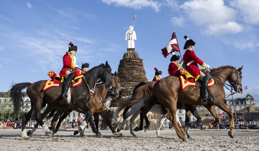 epa11280697 Men ride horses in the front of the Boeoegg figure is erected on the Sechselaeuten square in Zurich, Switzerland, 15 April 2024. Sechselaeuten (ringing of the six o&#039;clock bells) is a  ...
